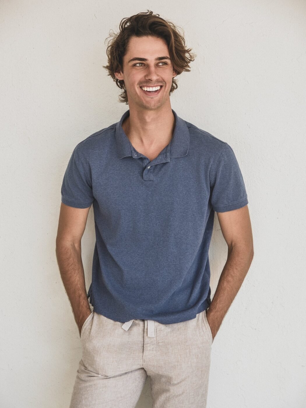 Ivan smiling in a blue polo against a white wall